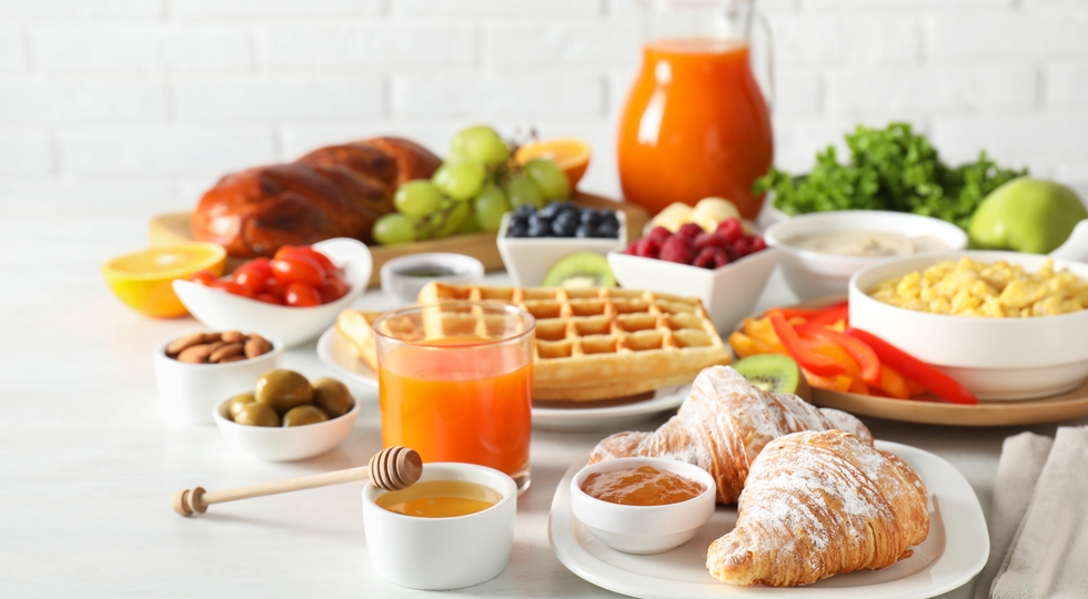 Tasty breakfast. Croissants, jam, honey and other food on light table